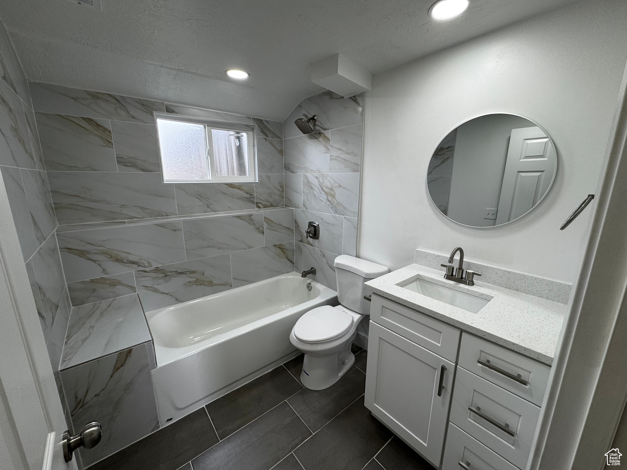 Full bathroom with tile patterned flooring, vanity, toilet, and tiled shower / bath