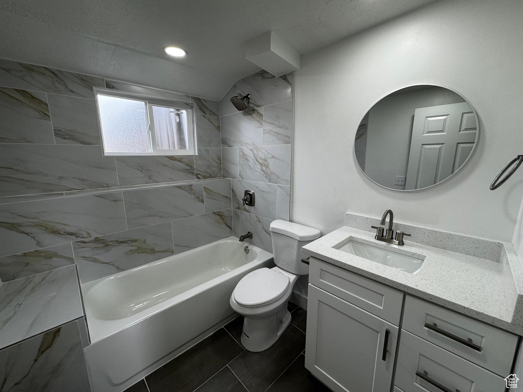 Full bathroom featuring vanity, toilet, and tiled shower / bath