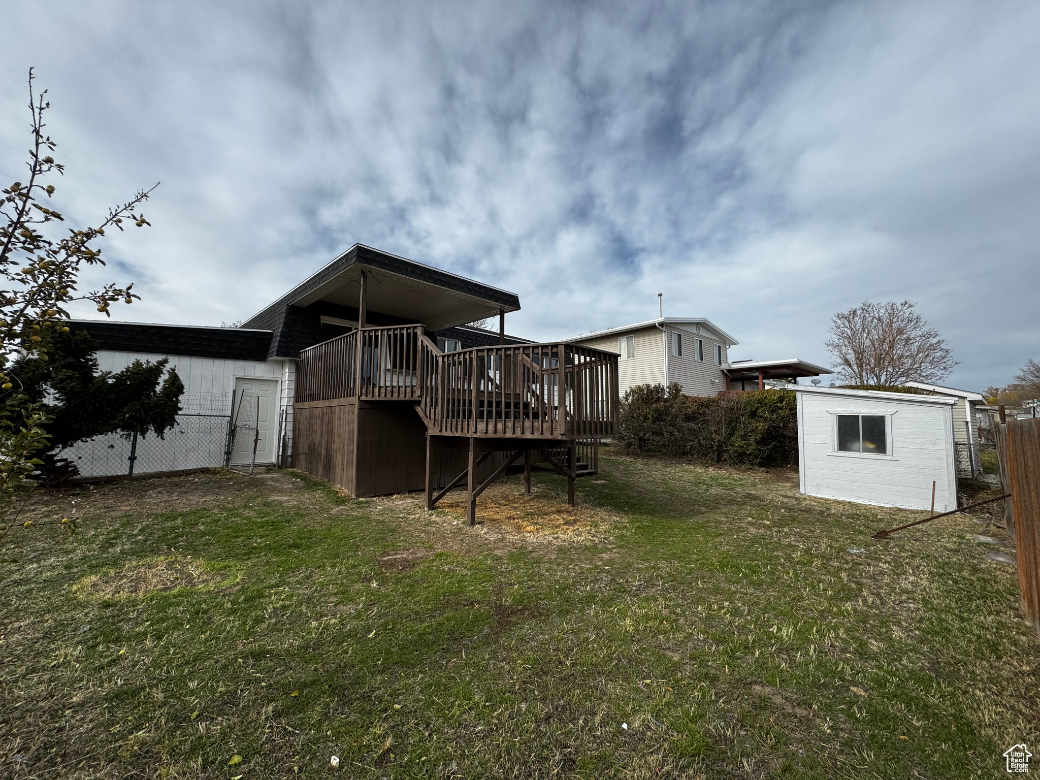 Back of house featuring a deck and a lawn