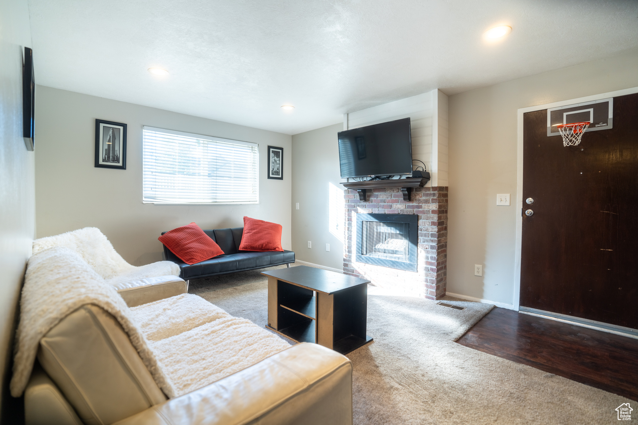 Living room with light wood-type flooring and a brick fireplace