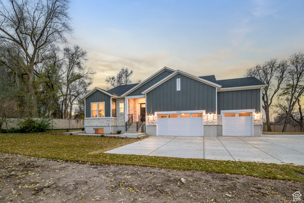 View of front of property with a yard and a garage