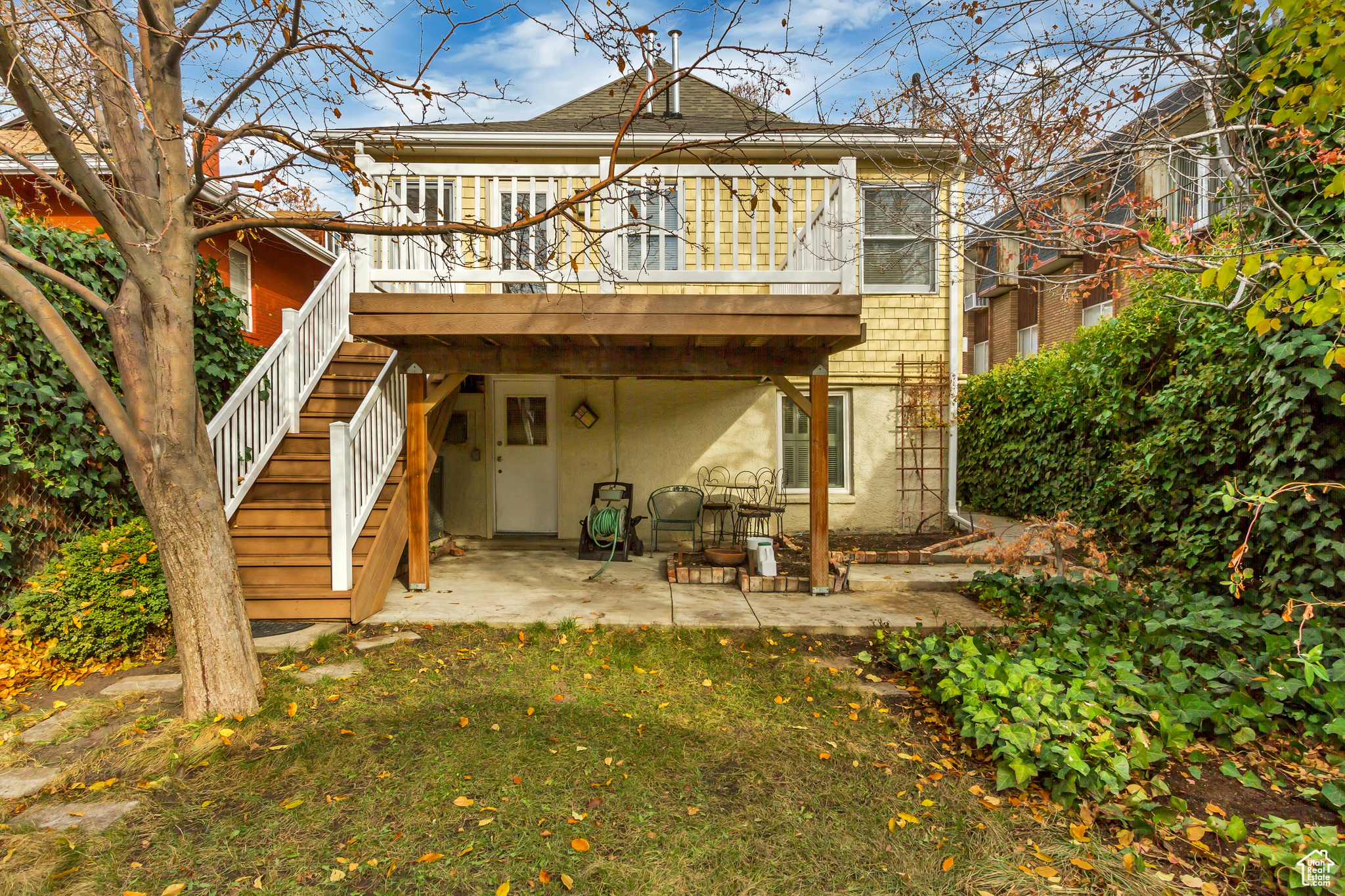 Rear view of property with a yard, a patio, and a deck. Apartment entrance is below the deck.