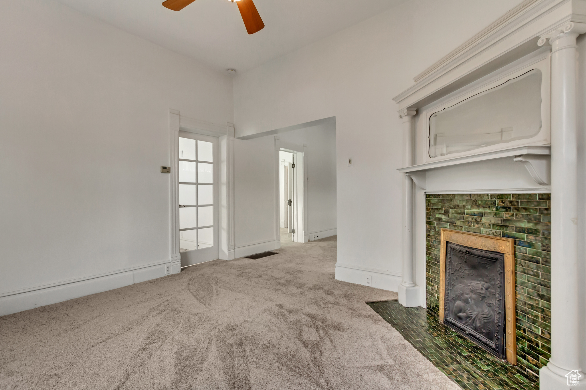 Unfurnished living room featuring carpet flooring and ceiling fan