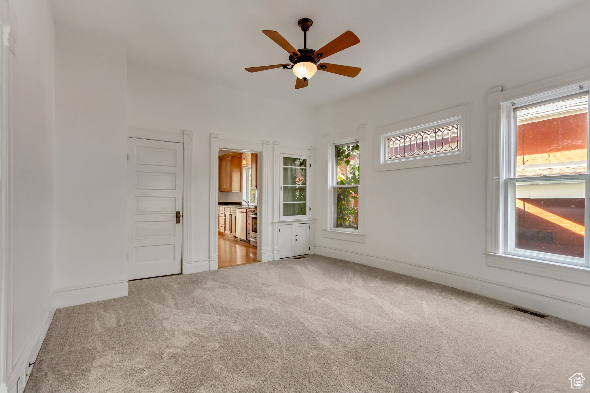 Spare room with light colored carpet, plenty of natural light, and ceiling fan