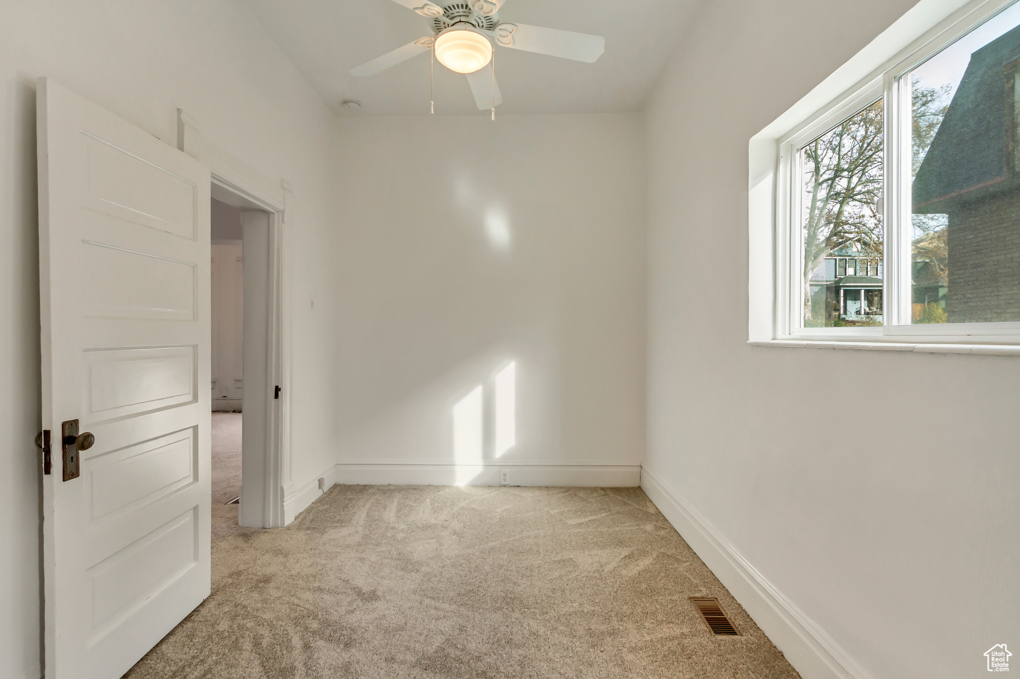 Unfurnished room with ceiling fan and light colored carpet