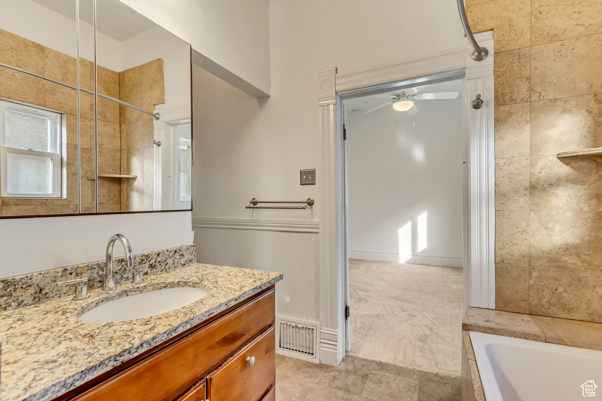 Bathroom featuring vanity, ceiling fan, and a tub to relax in