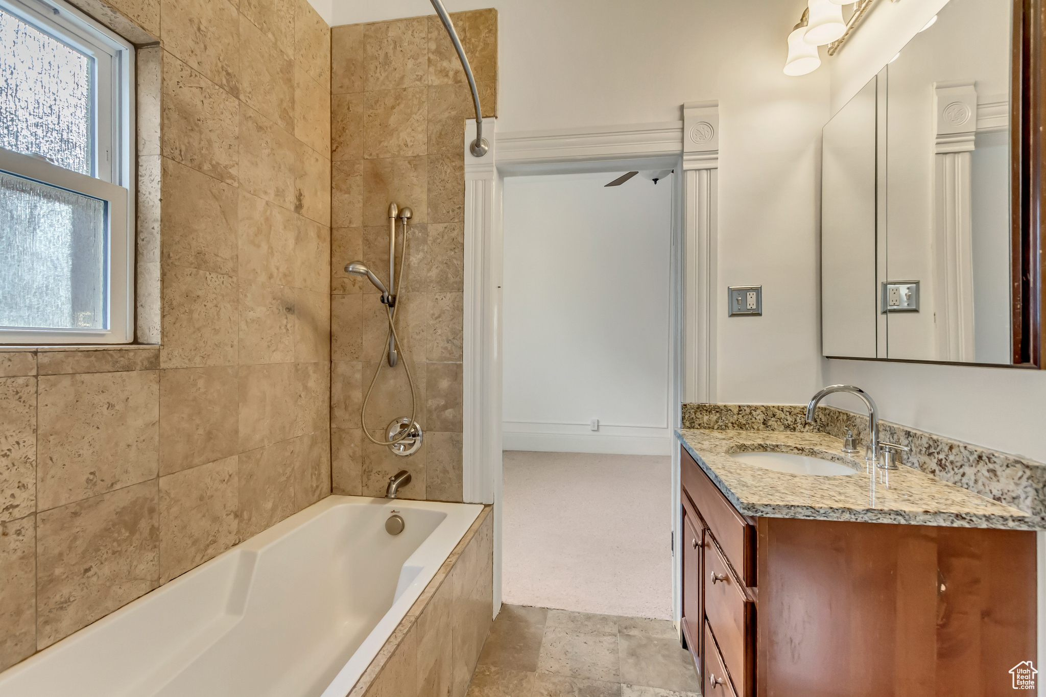 Bathroom with ceiling fan, vanity, and tiled shower / bath