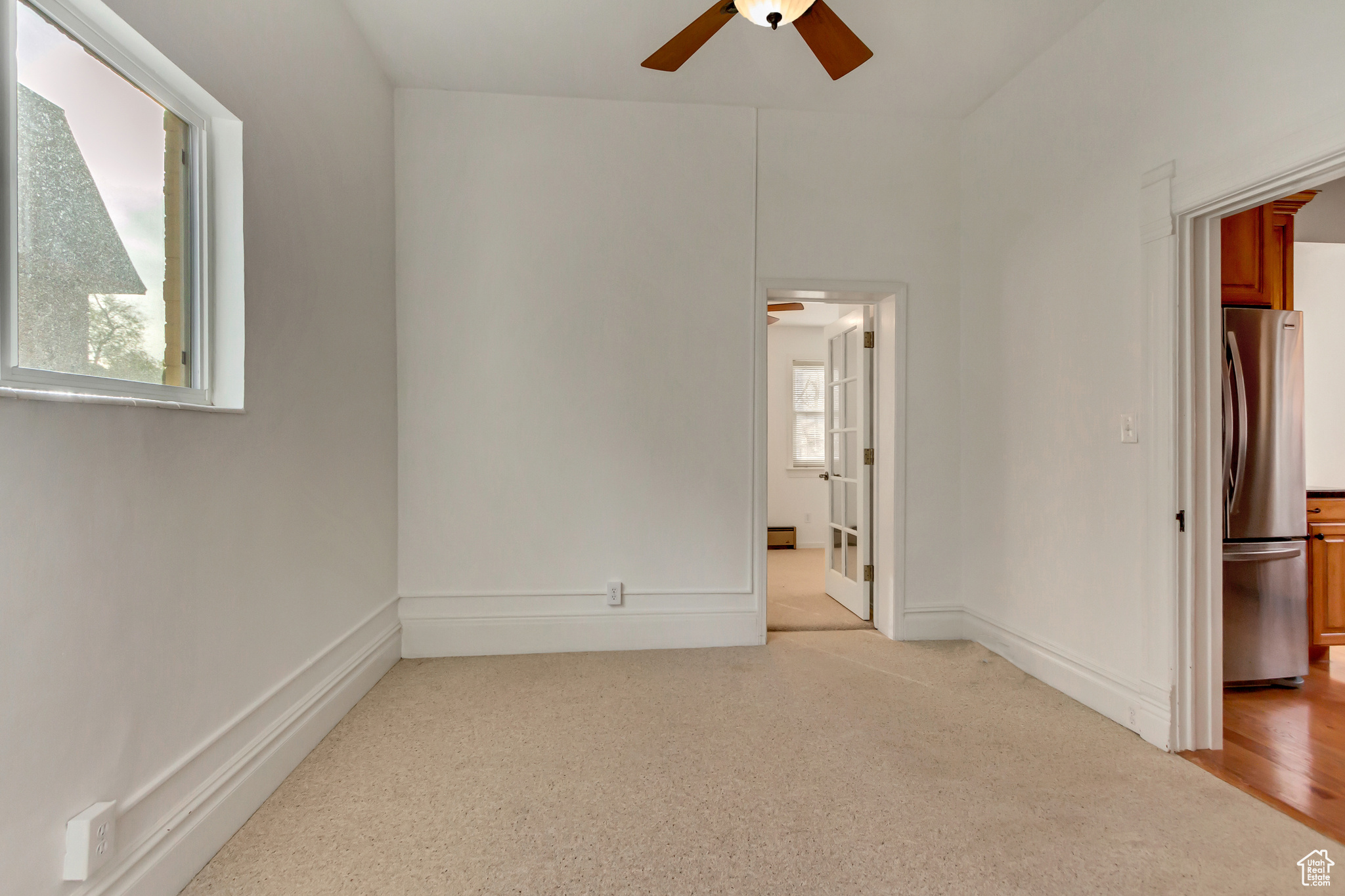 Unfurnished room with ceiling fan and light hardwood / wood-style floors