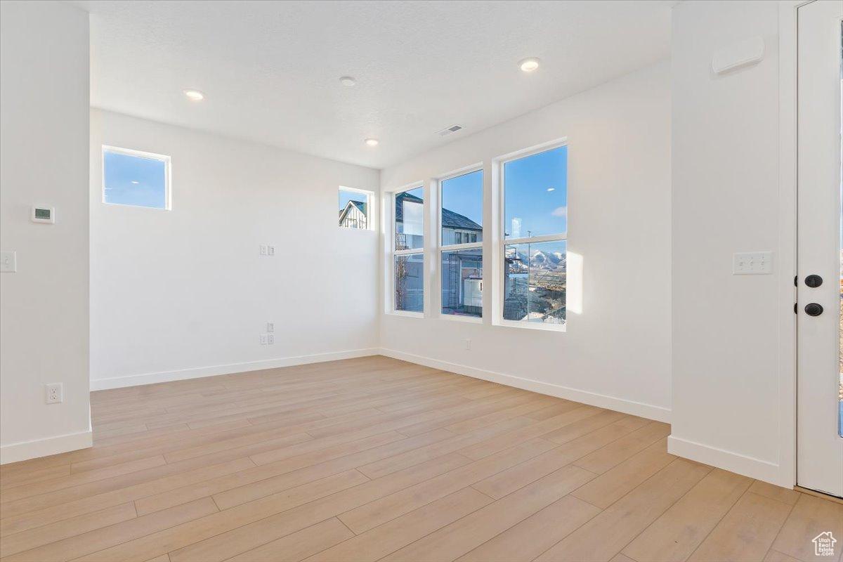 Empty room with light hardwood / wood-style flooring