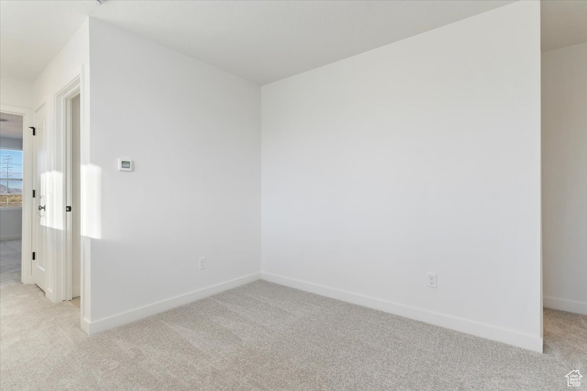 Empty room featuring light colored carpet