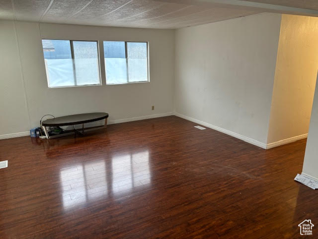 Empty room featuring dark hardwood / wood-style floors