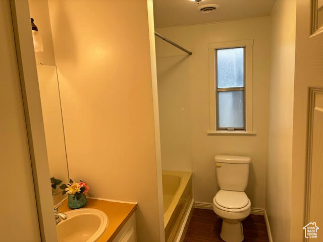 Bathroom with wood-type flooring, vanity, and toilet