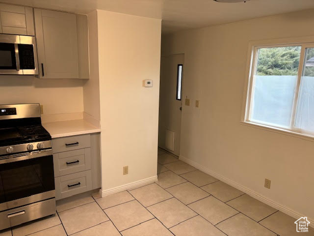 Kitchen with light tile patterned floors and stainless steel appliances