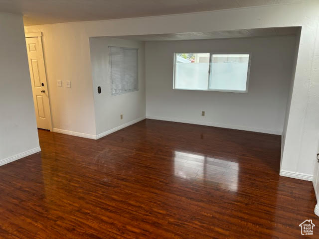 Empty room with dark hardwood / wood-style floors