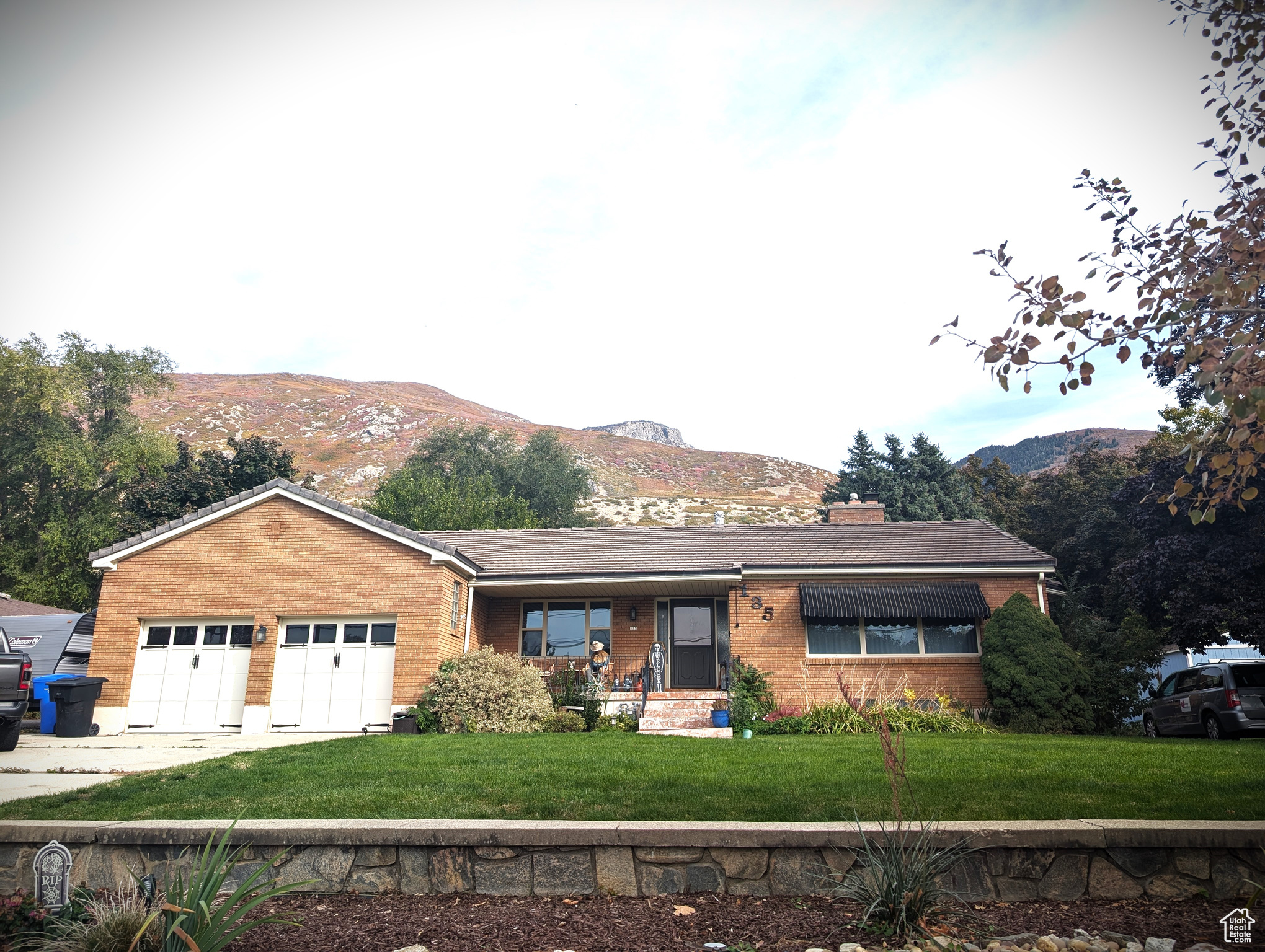 Single story home featuring a mountain view, a garage, and a front lawn