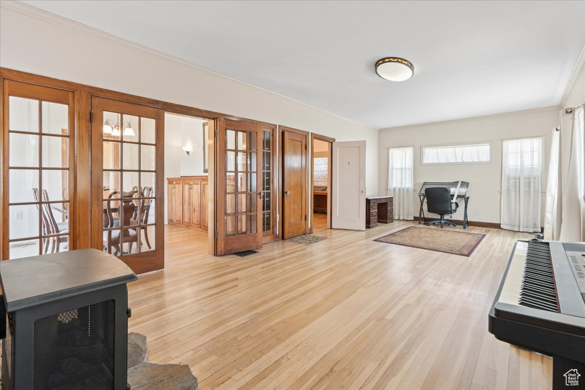 Living room featuring light hardwood / wood-style floors, french doors, and ornamental molding