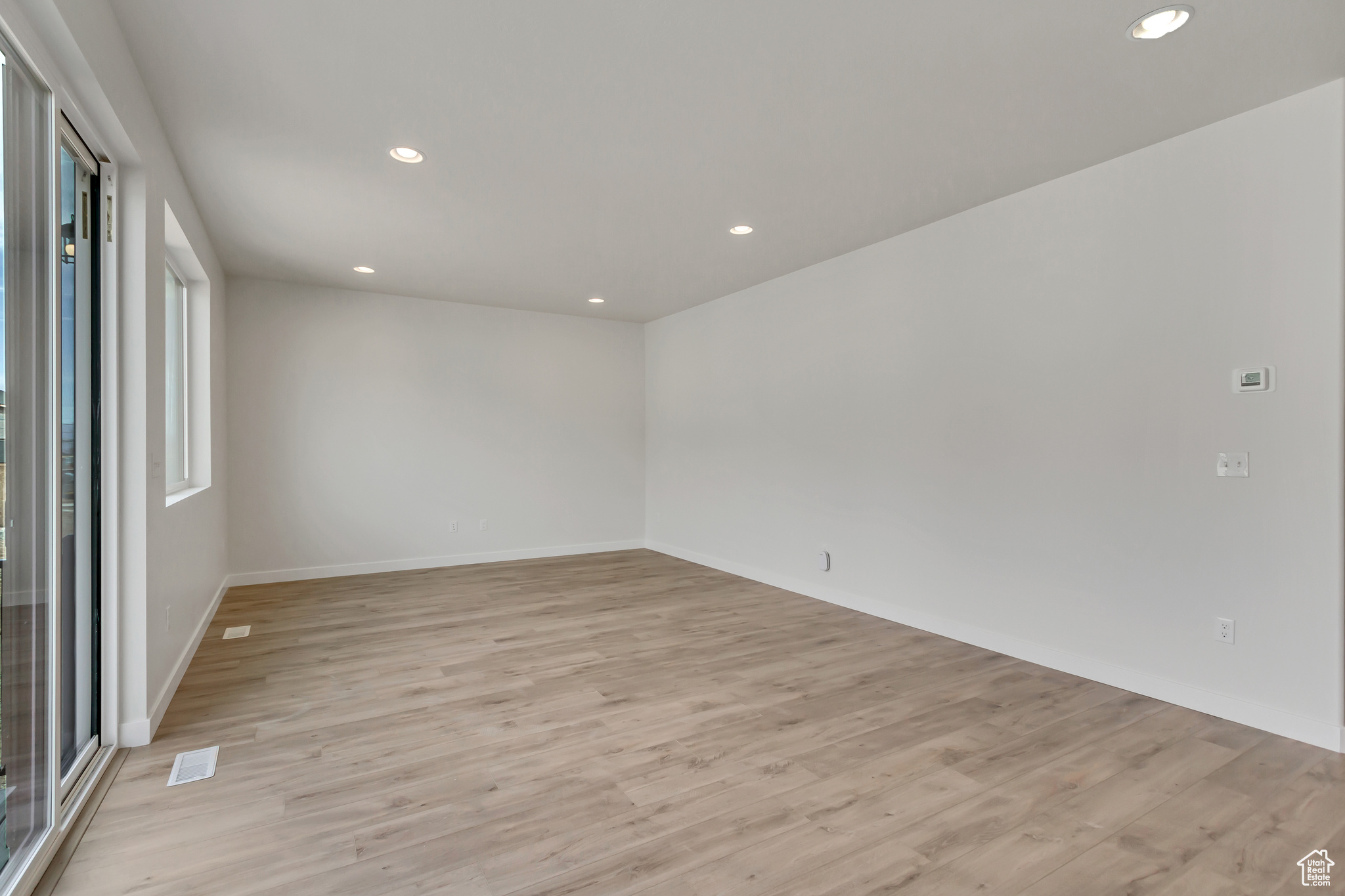 Unfurnished room with light wood-type flooring and a healthy amount of sunlight