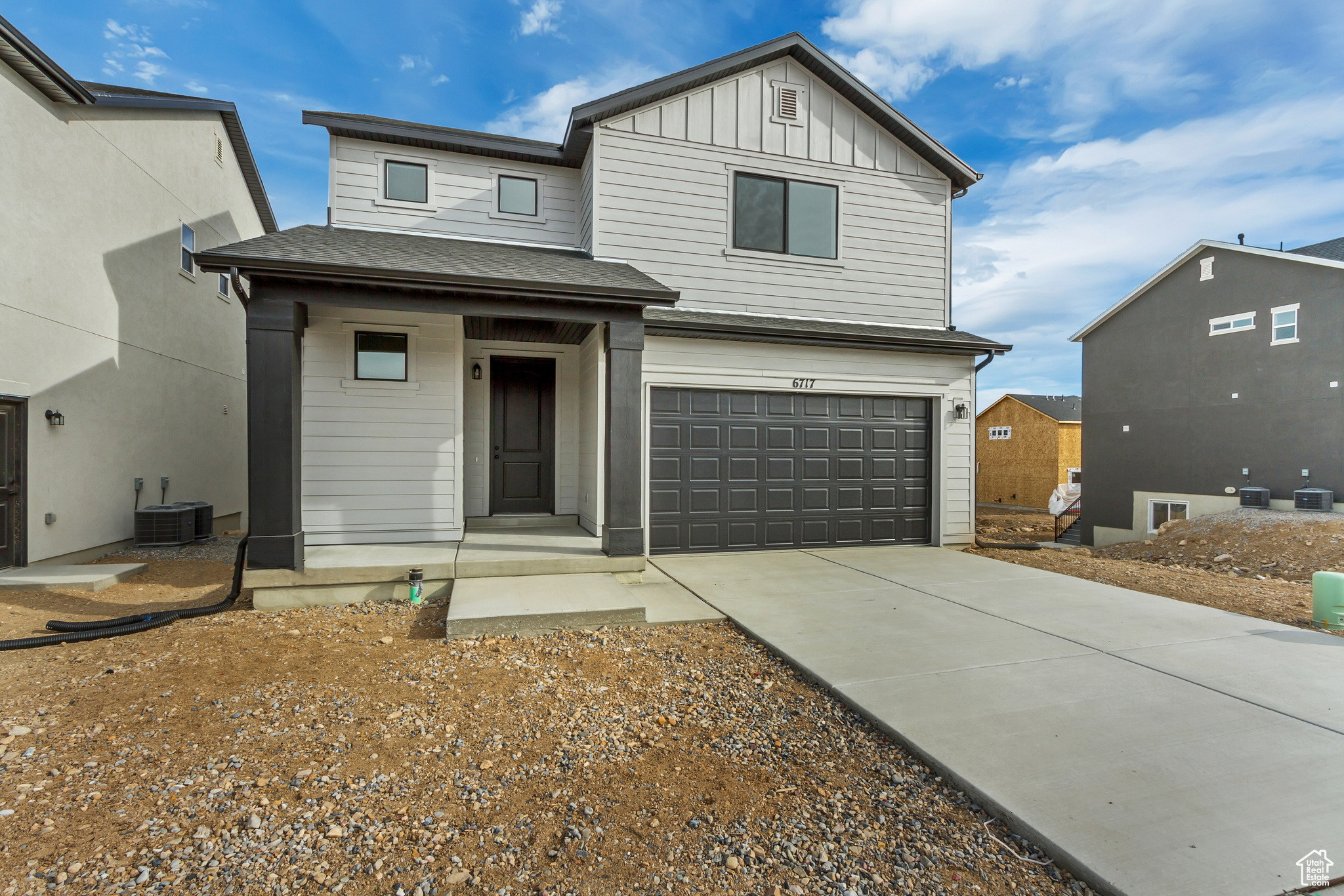 View of front of house featuring a garage and central air condition unit