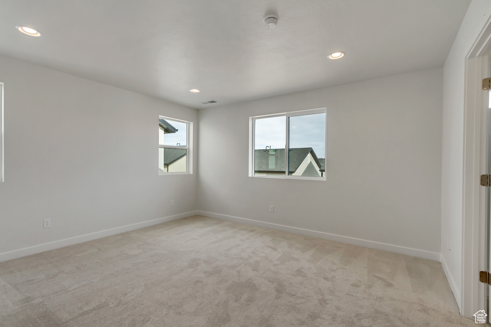 Empty room featuring light colored carpet