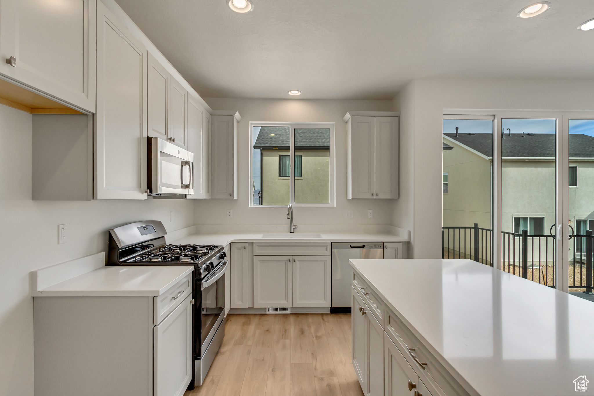 Kitchen featuring a healthy amount of sunlight, sink, stainless steel appliances, and light hardwood / wood-style flooring