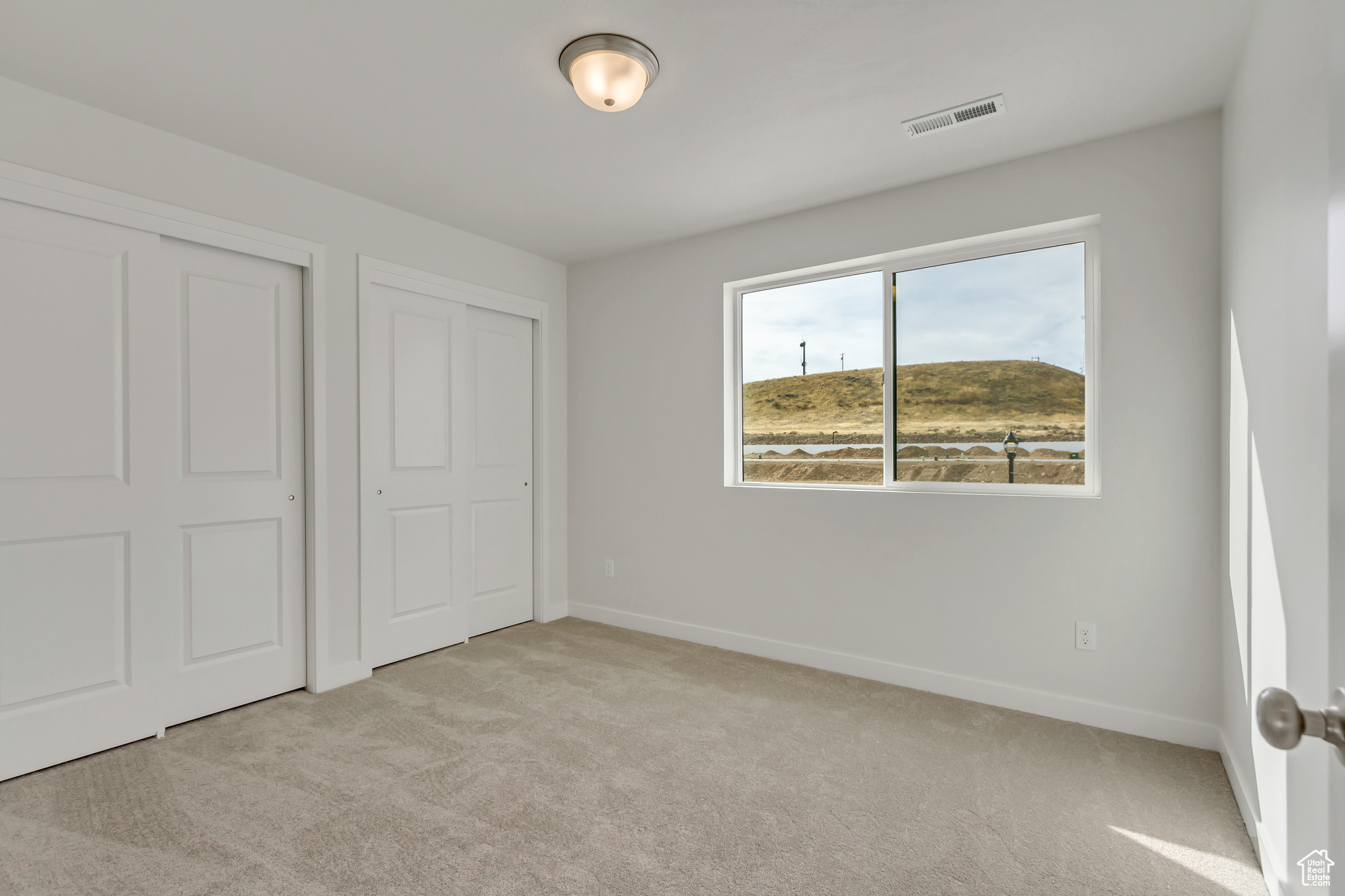 Unfurnished bedroom featuring light carpet