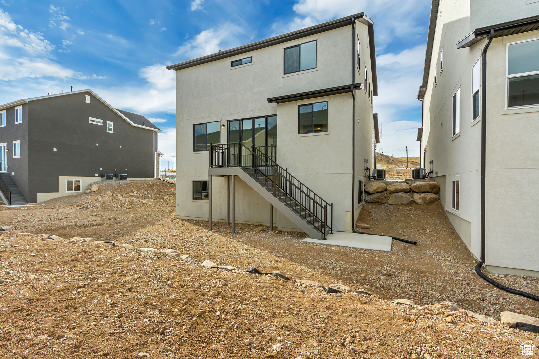 Rear view of property featuring central AC