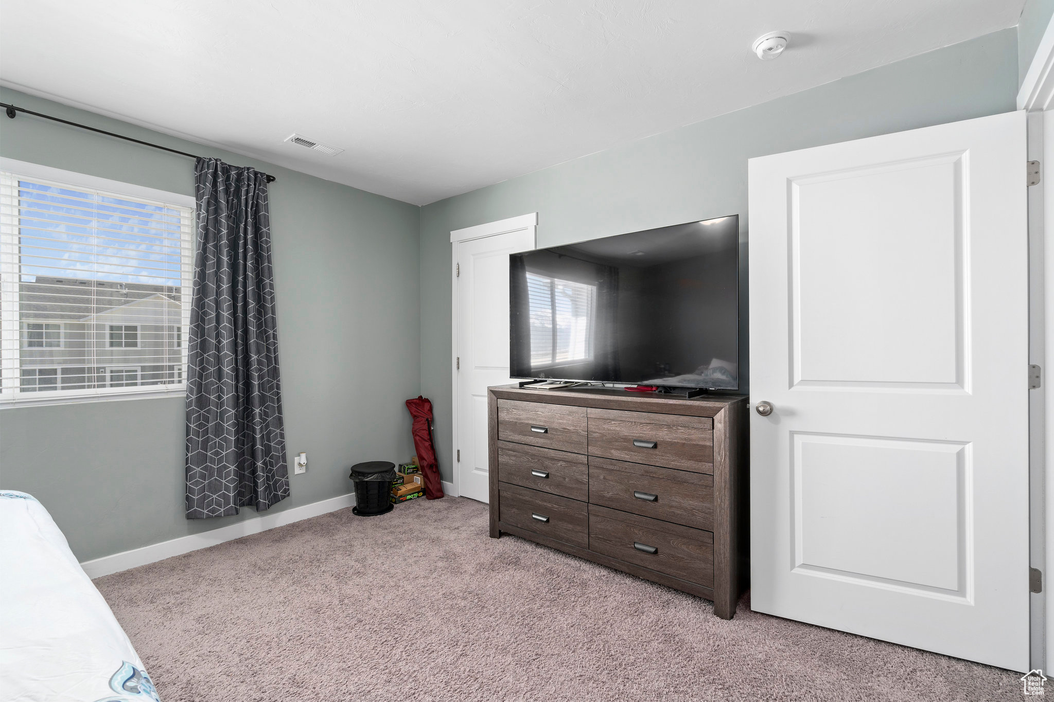 Bedroom featuring light colored carpet