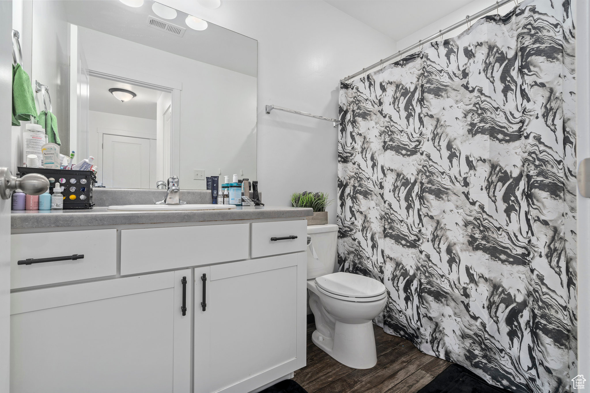 Bathroom featuring hardwood / wood-style flooring, vanity, toilet, and walk in shower