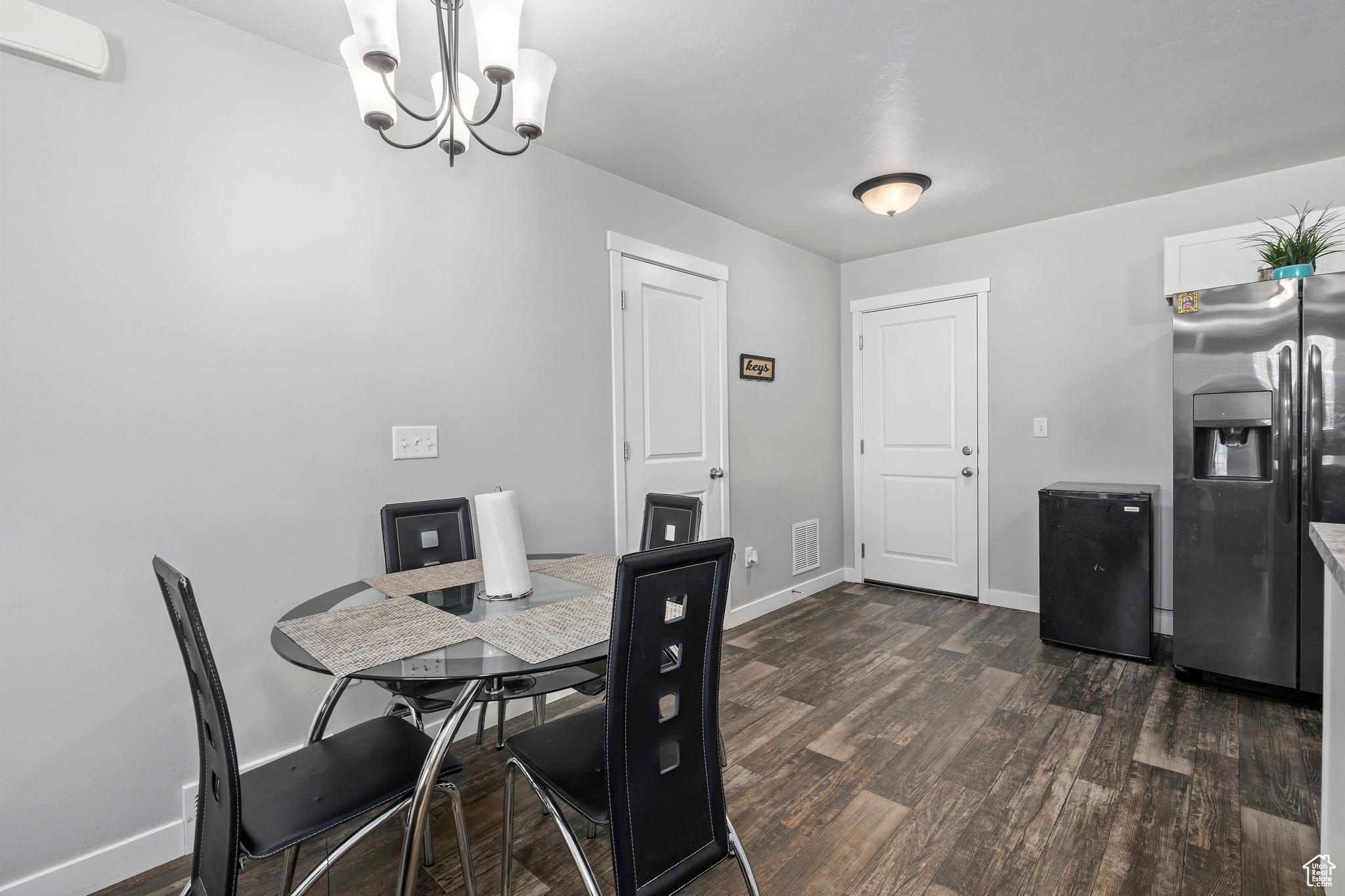 Dining space featuring dark hardwood / wood-style floors and a notable chandelier