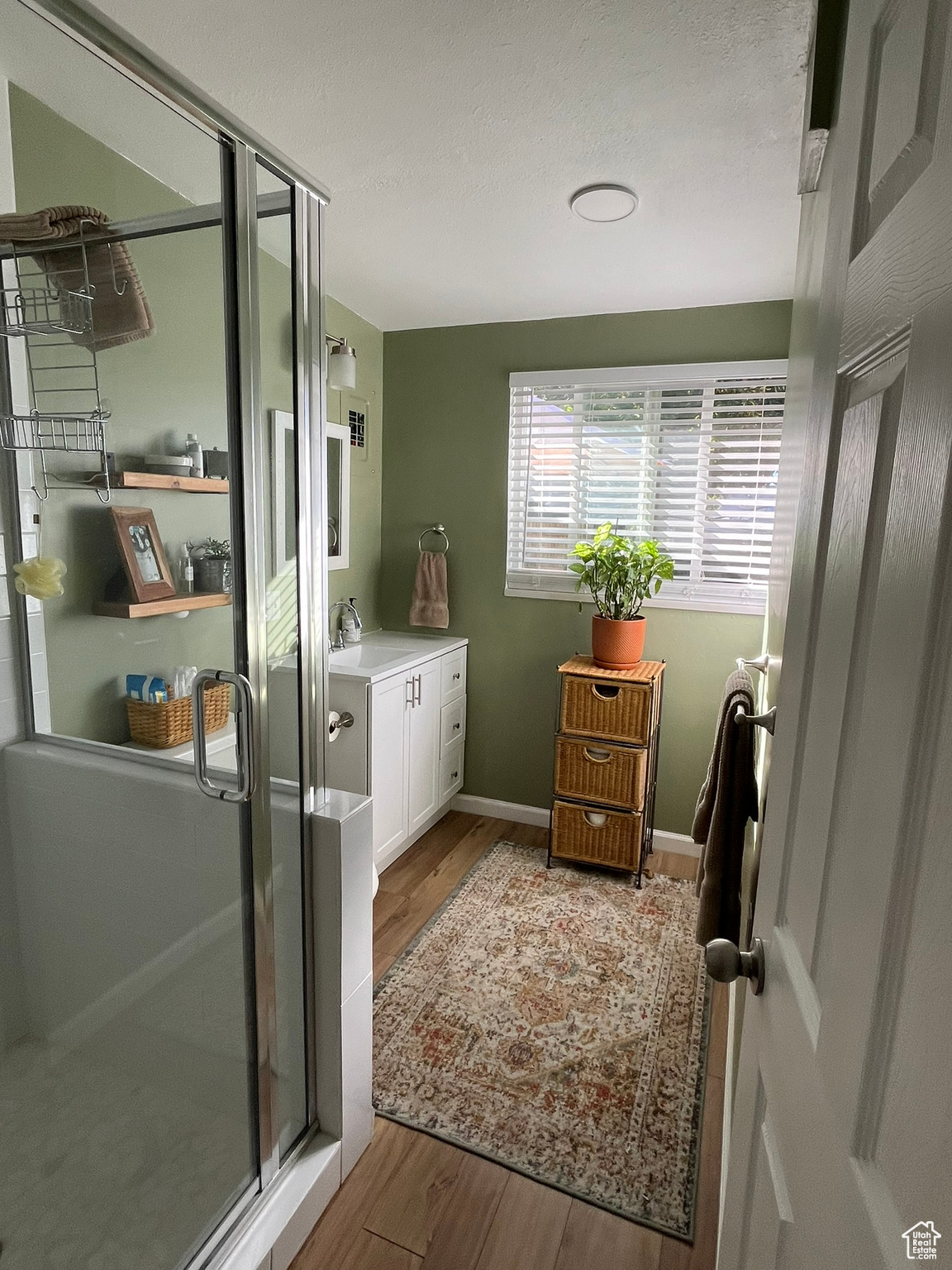 Bathroom featuring vanity, wood-type flooring, and a shower with shower door