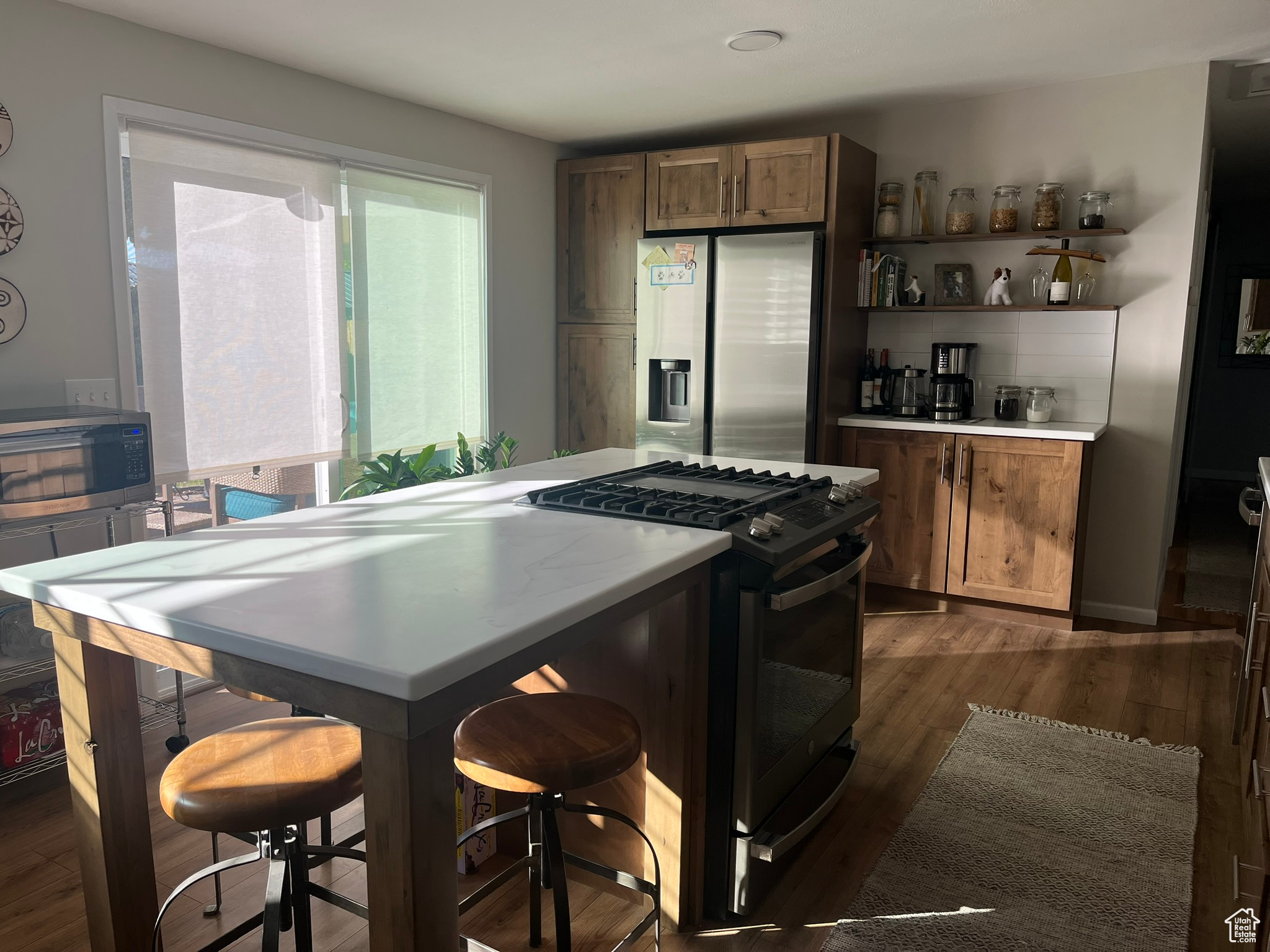 Kitchen featuring tasteful backsplash, dark wood-type flooring, and appliances with stainless steel finishes