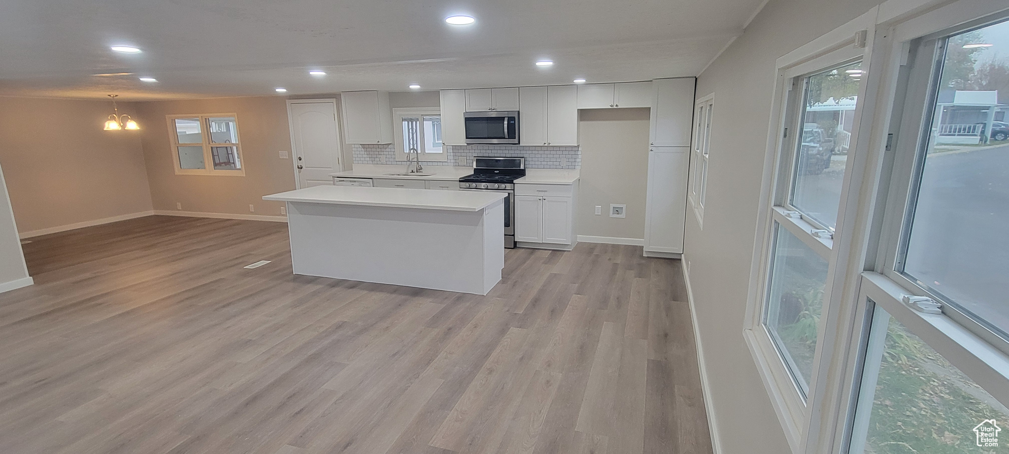 Kitchen featuring sink, white cabinets, stainless steel appliances, and light hardwood / wood-style flooring