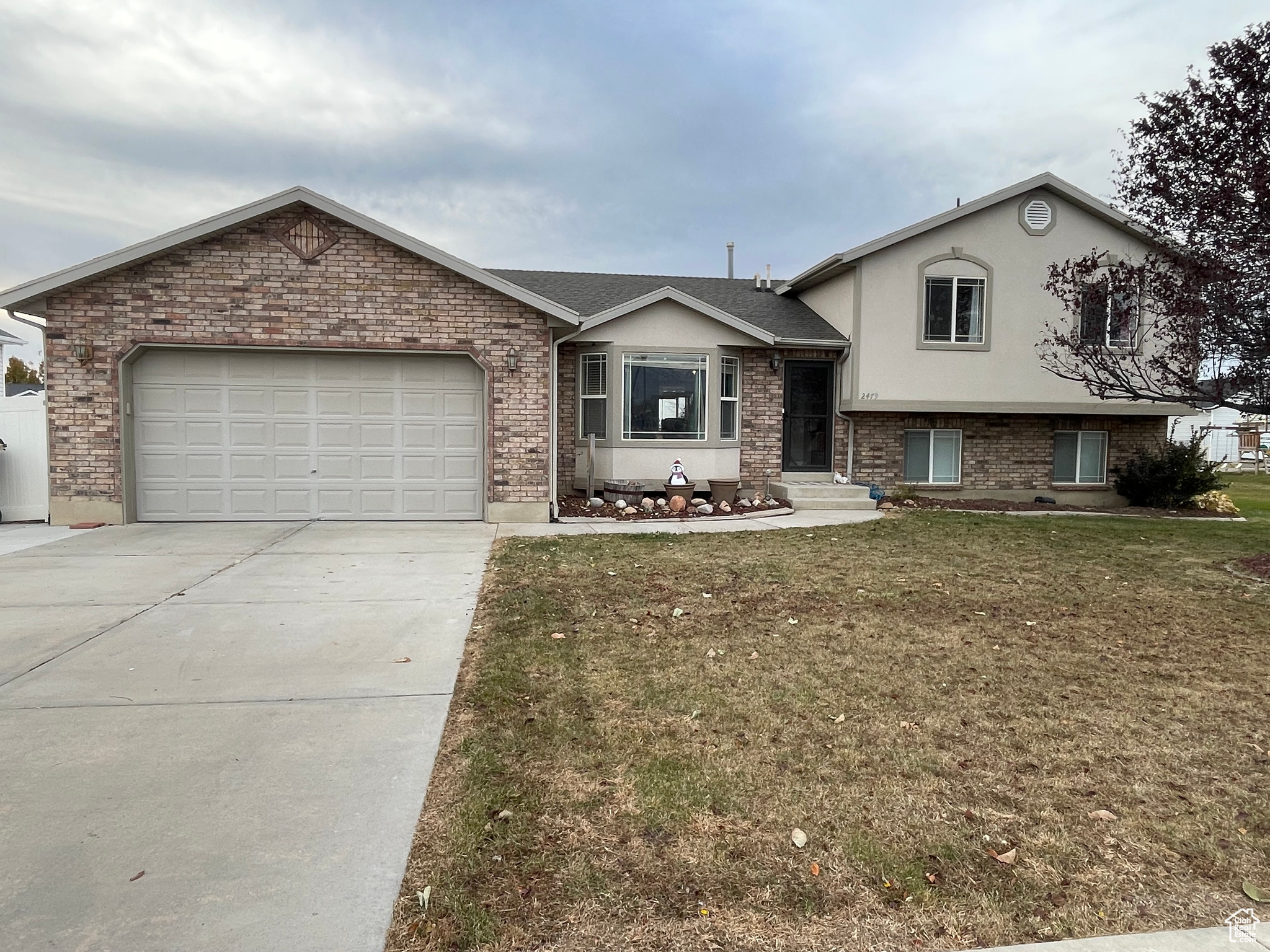 Split level home featuring a garage and a front lawn