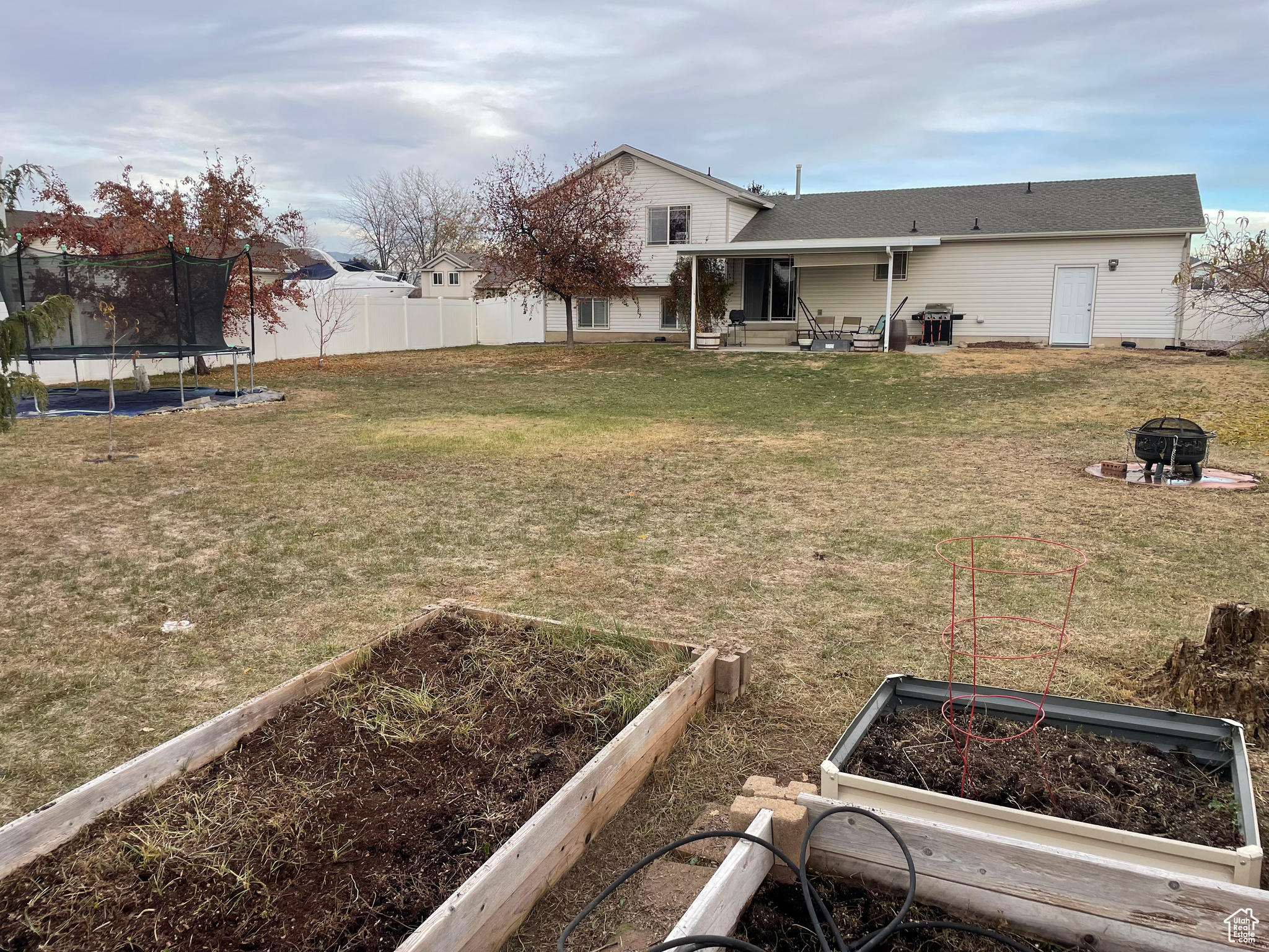 View of yard with a trampoline and an outdoor fire pit