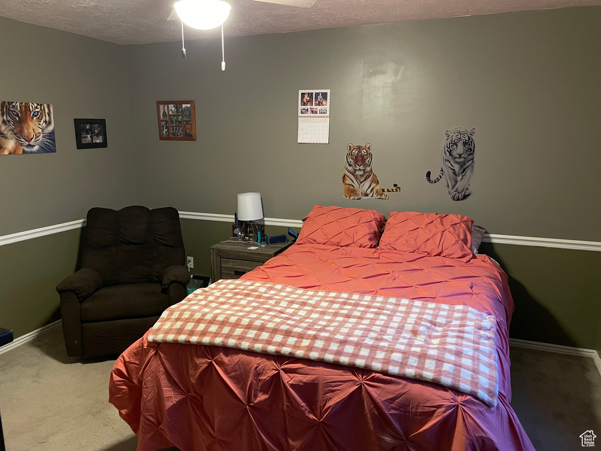 Carpeted bedroom with ceiling fan and a textured ceiling