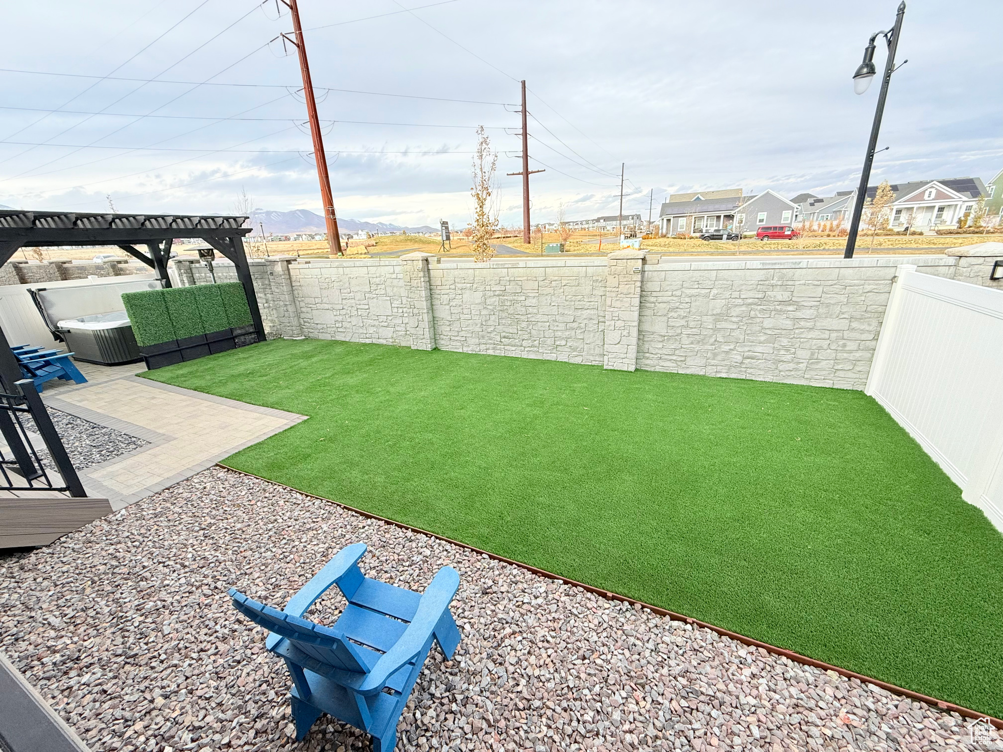 View of back yard with high quality artificial grass, privacy wall and xeriscape.