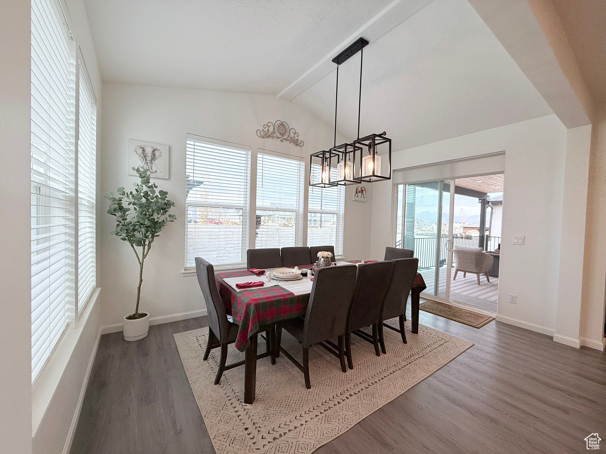 Sunroom room featuring vaulted ceiling with beams, an inviting chandelier, and wealth of natural light.