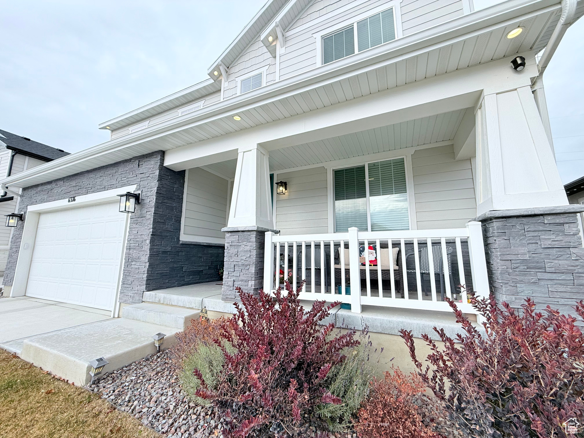 Property entrance with a covered porch and a garage