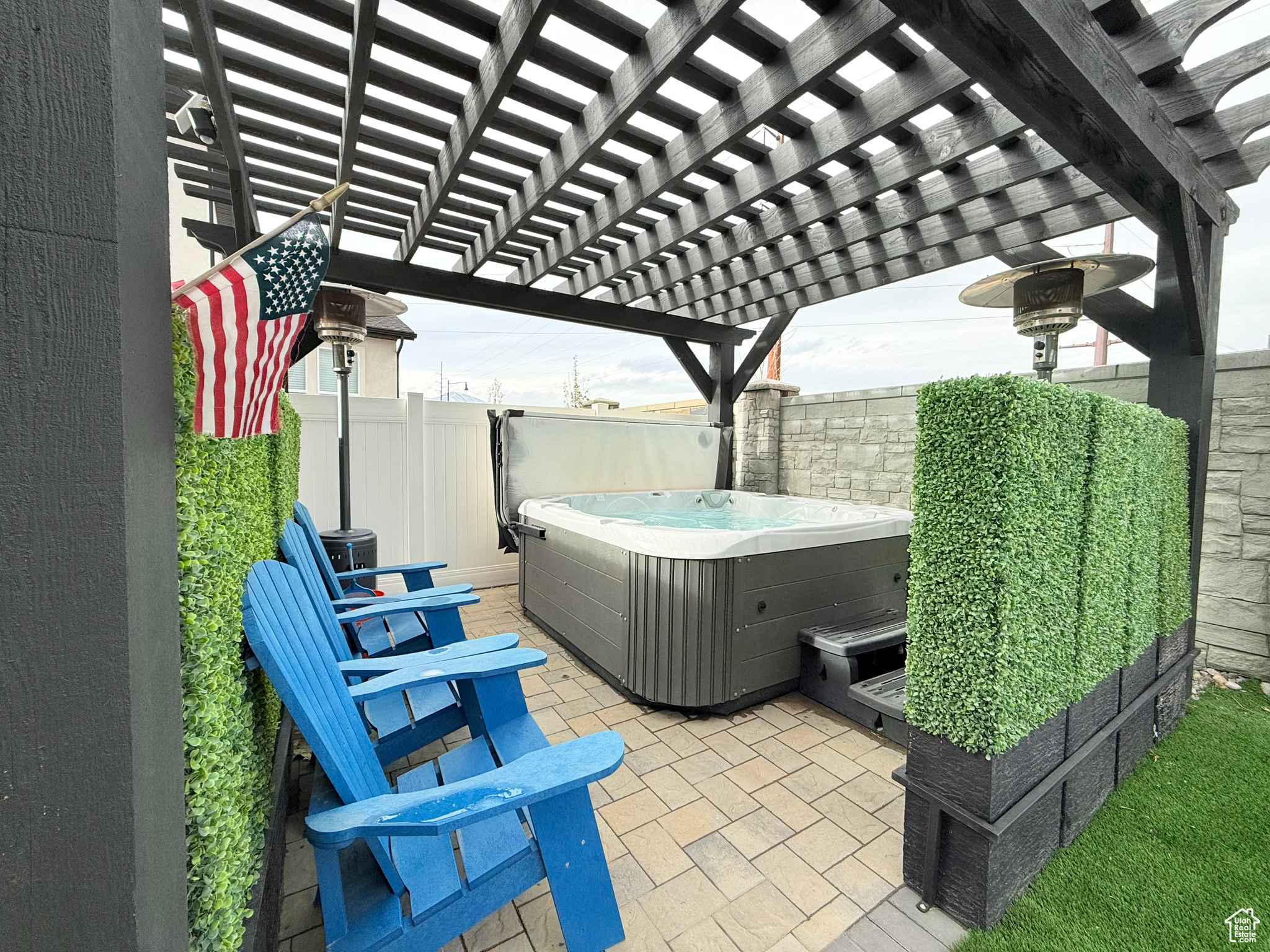 View of patio featuring a pergola and a hot tub with privacy walls