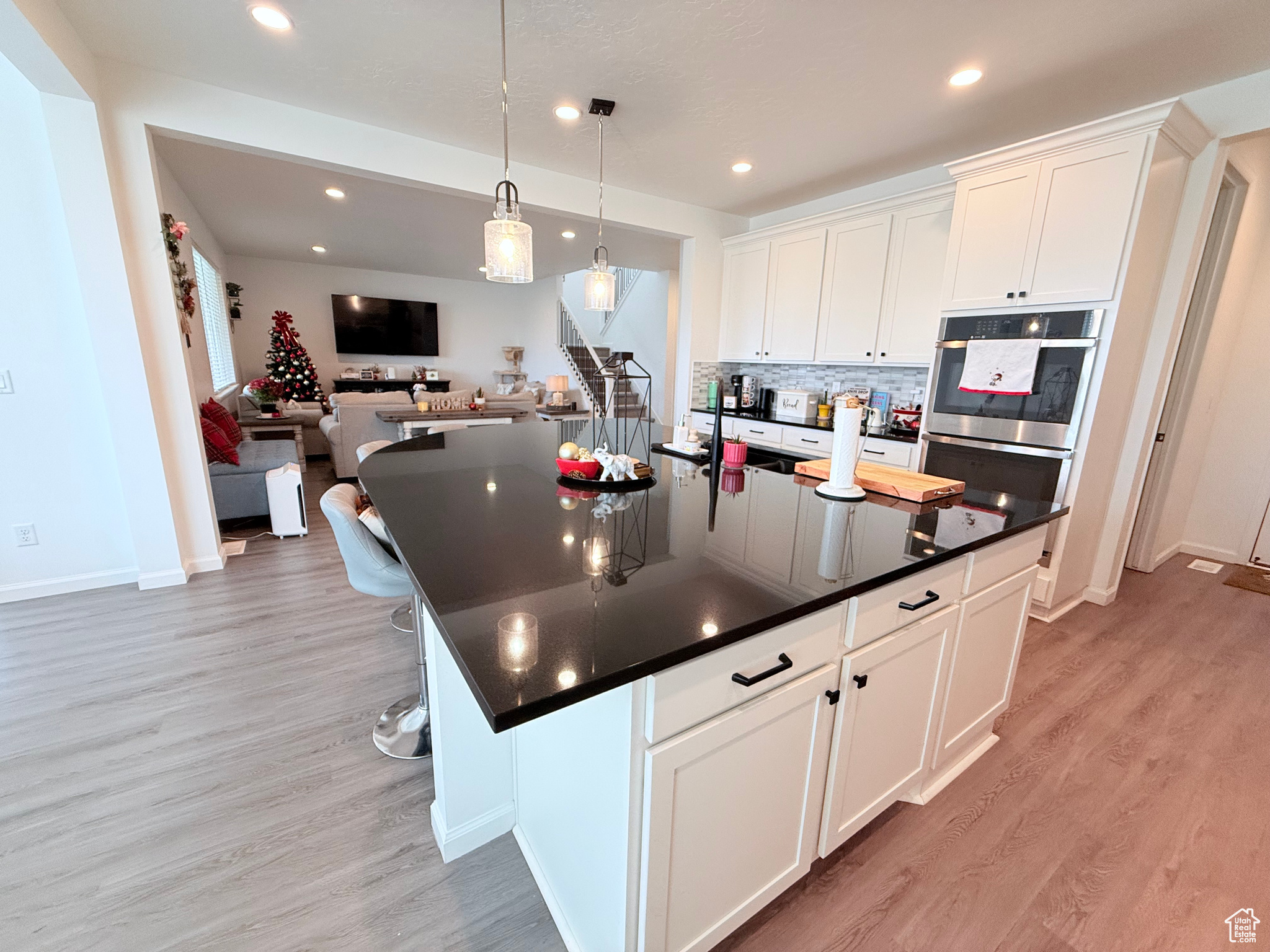 Kitchen featuring white cabinetry, tasteful backsplash & a custom gourmet kitchen island