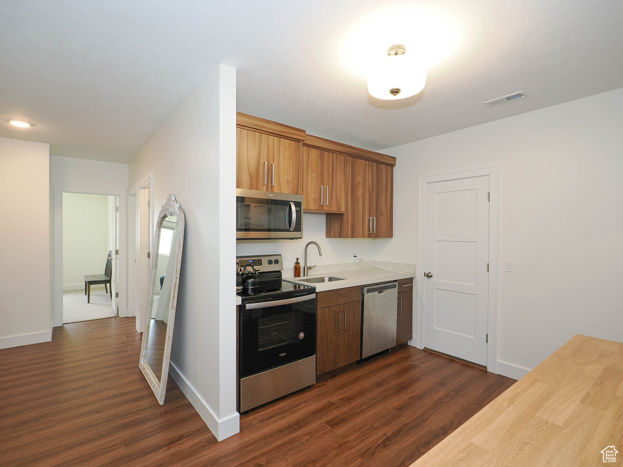 Kitchen with sink, dark hardwood / wood-style floors, and appliances with stainless steel finishes
