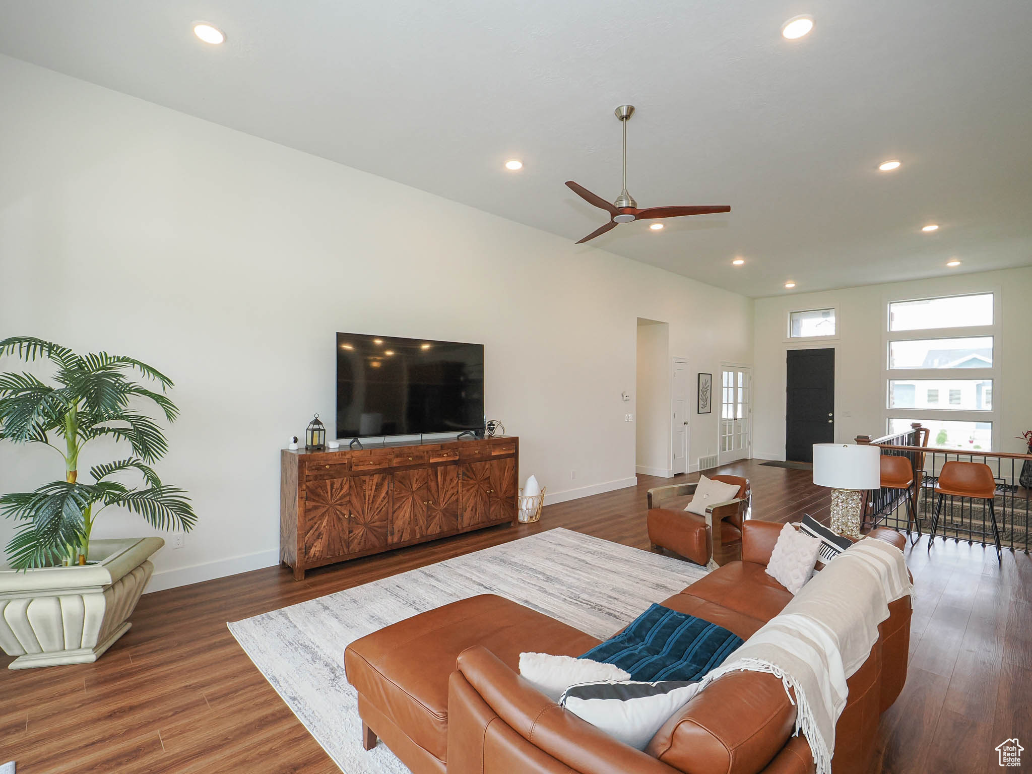 Living room with ceiling fan and hardwood / wood-style floors
