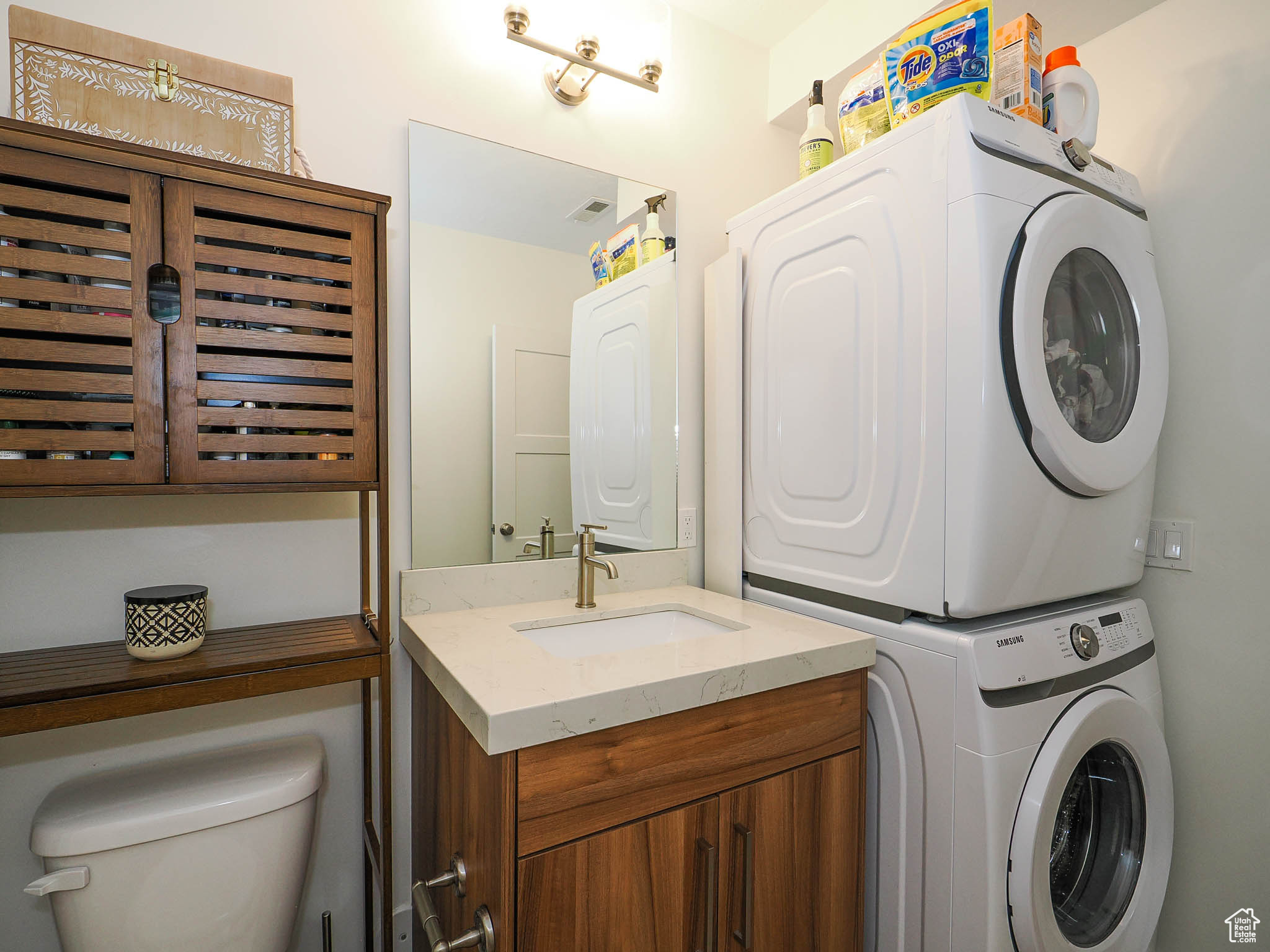 Clothes washing area with stacked washer and clothes dryer and sink