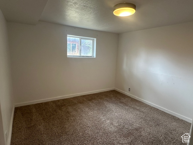 Carpeted empty room with a textured ceiling