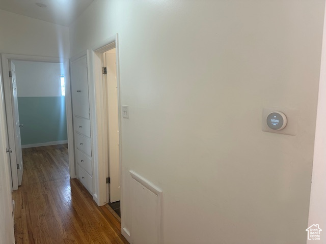 Corridor with hardwood / wood-style floors