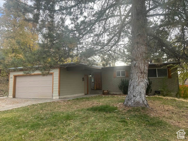 Ranch-style house with a garage and a front lawn