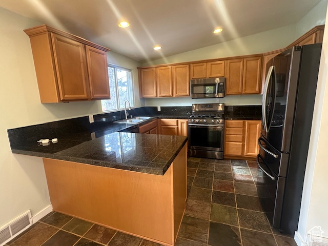 Kitchen with kitchen peninsula, sink, lofted ceiling, and appliances with stainless steel finishes