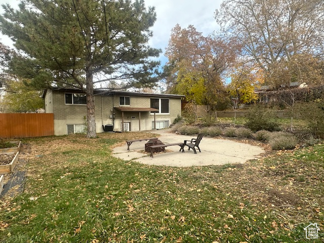 Rear view of property featuring a yard and a fire pit