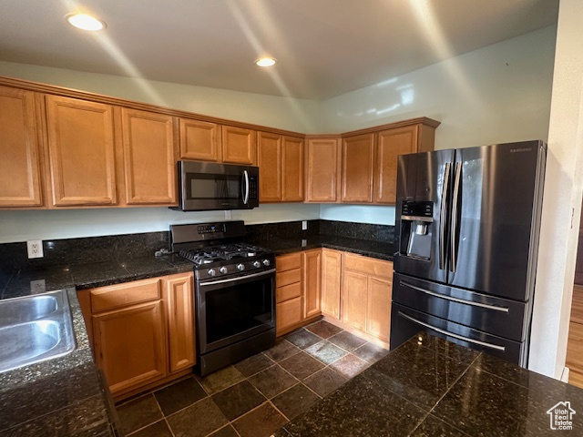 Kitchen featuring appliances with stainless steel finishes, lofted ceiling, and sink