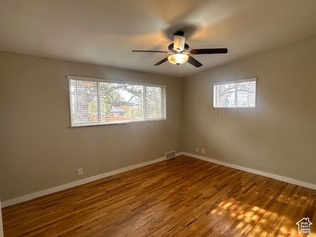 Unfurnished room featuring ceiling fan, hardwood / wood-style floors, and vaulted ceiling